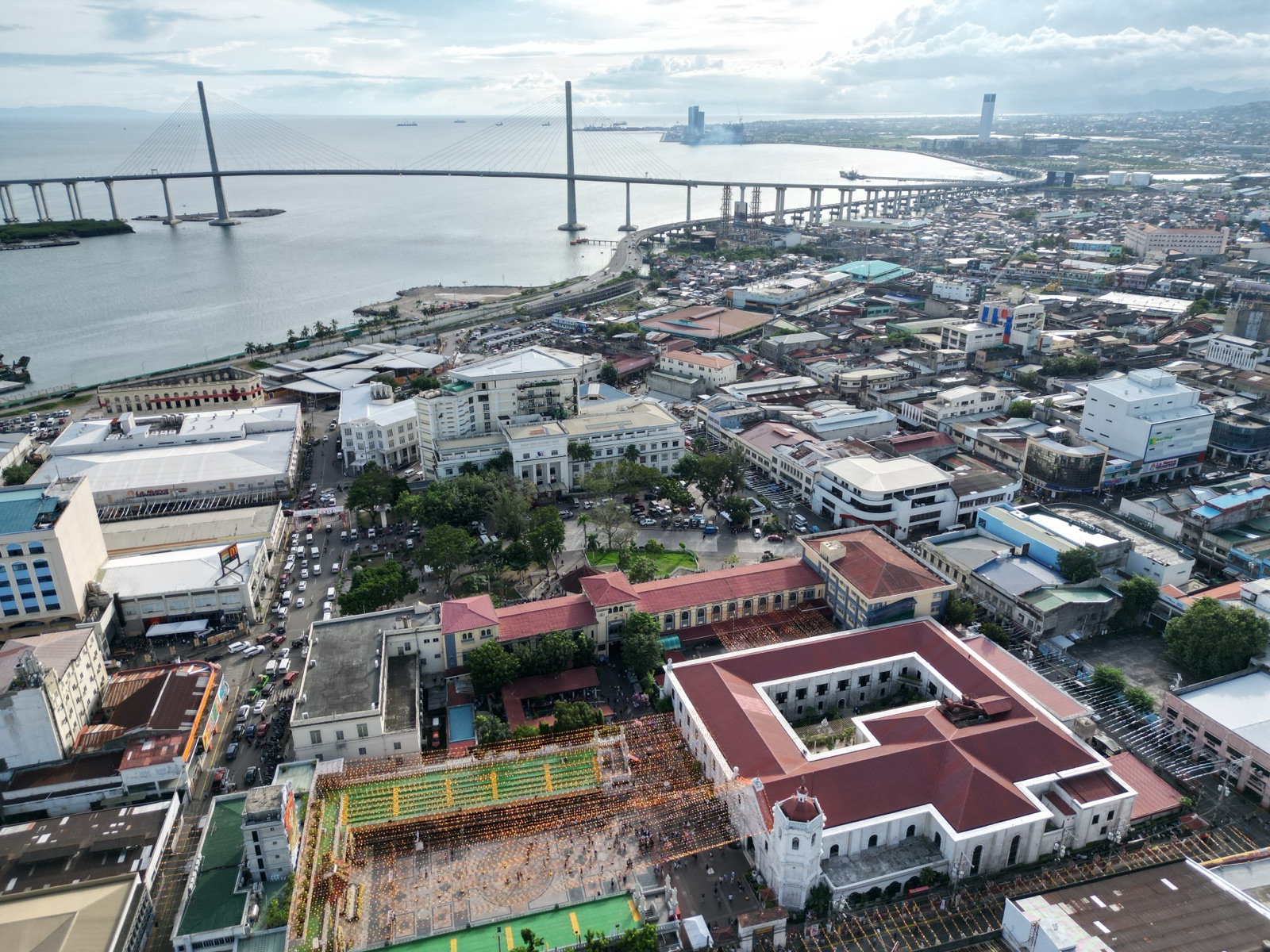 Aerial view of downtown Cebu City with the Basilica del Santo Niño in the foreground and the Cebu–Cordova bridge behind