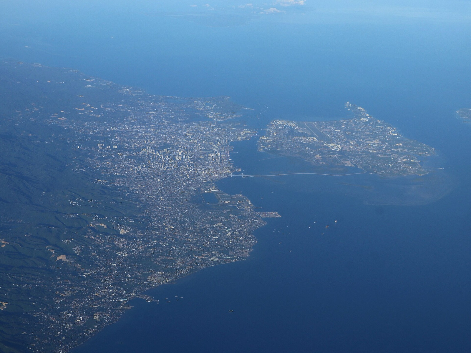 Metro Cebu and Mactan Island from the air, with the airport runway and the bridges across the channel