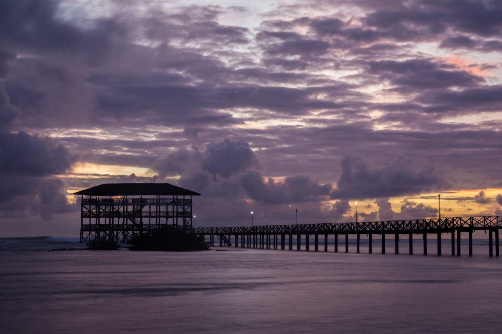 The wooden Cloud 9 boardwalk stretching over the reef at sunrise in General Luna, Siargao