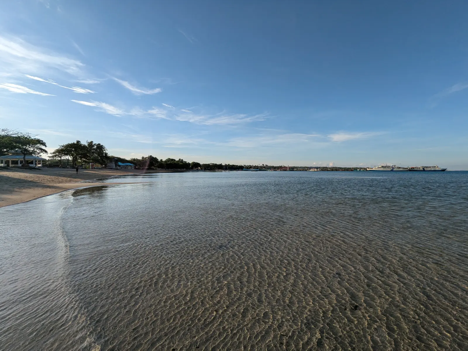 Calm shallow water off Cuyo’s port, with an inter-island ferry anchored offshore near the town waterfront
